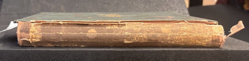 Damaged spine and surviving green cloth