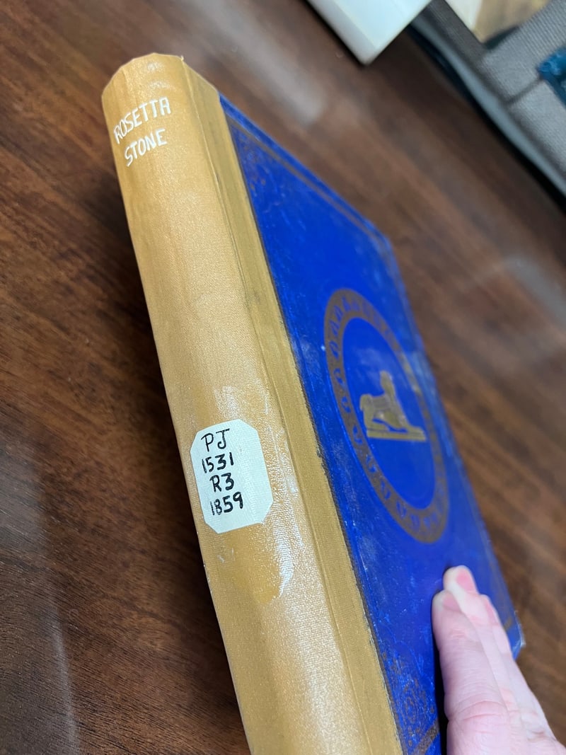 S086: Blue front board with gilt sphinx and tan cloth spine hand-lettered “ROSETTA STONE”