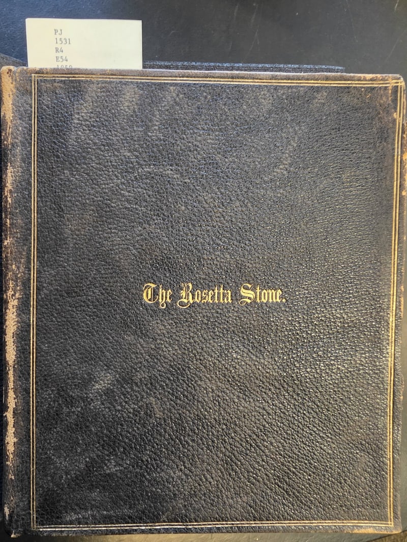 Black limp pebble-grain leather front cover lettered in gilt “The Rosetta Stone.”