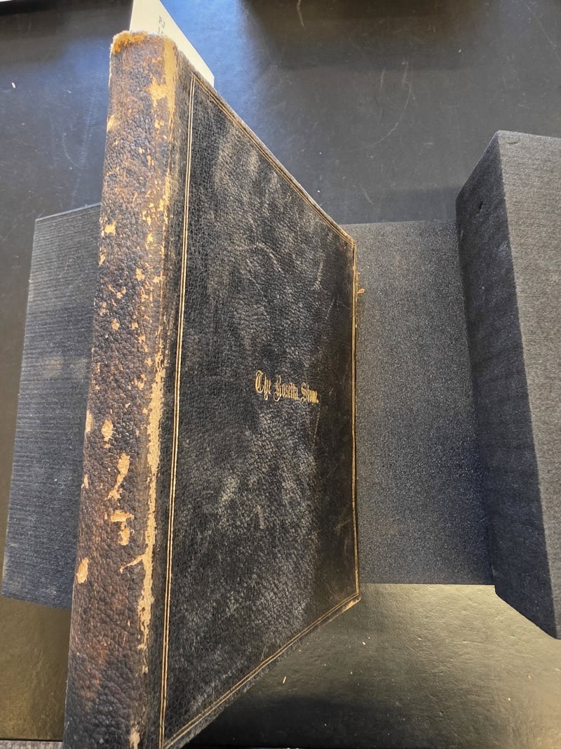 Spine of the black limp leather binding